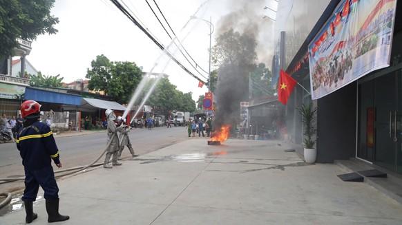Các lực lượng phối hợp triển khai đội hình, phun nước khống chế đám cháy giả định.