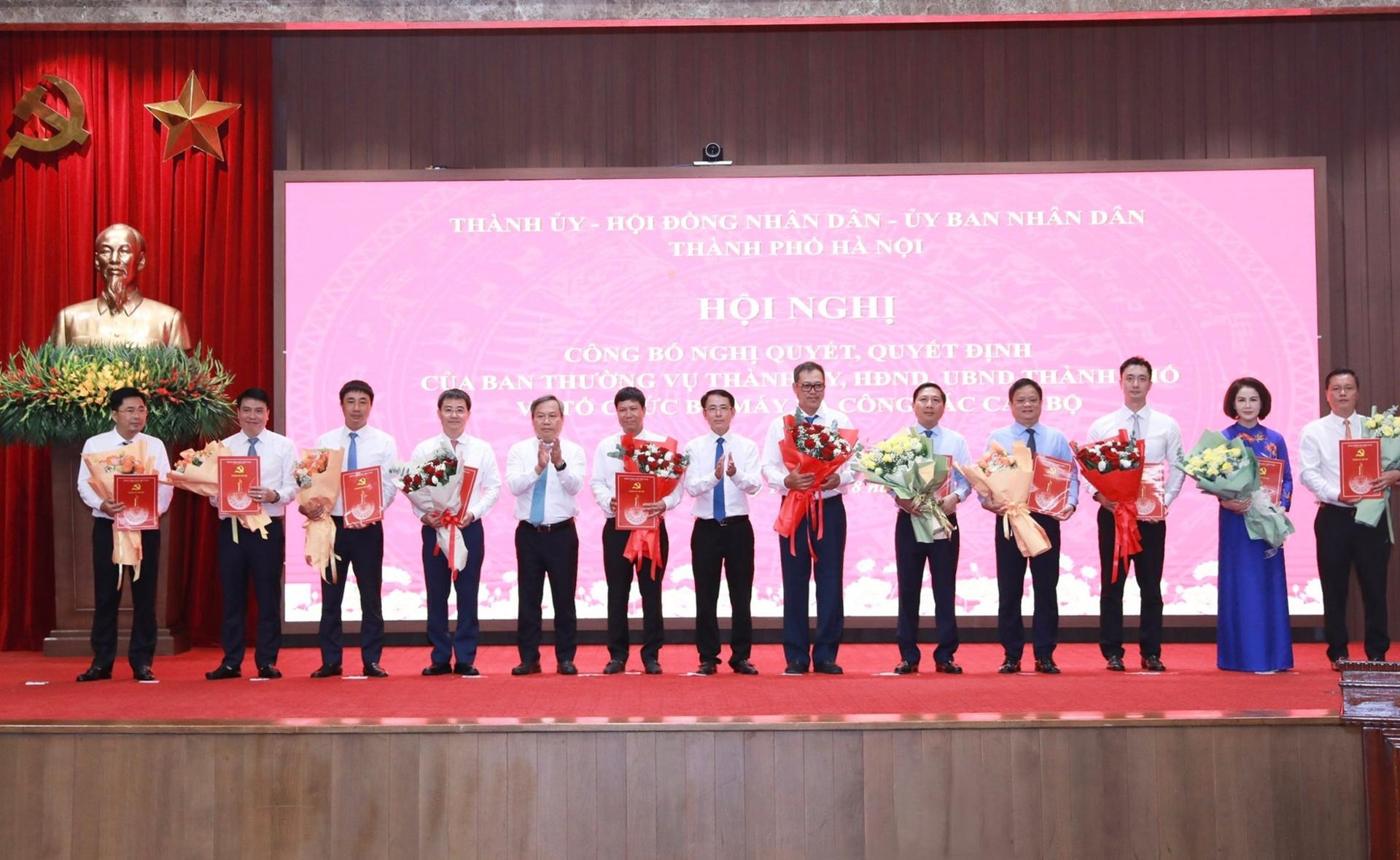 Phó Bí thư Thường trực Thành ủy Hà Nội Nguyễn Trọng Đông; Phó Bí thư Thành ủy, Chủ tịch UBND thành phố Hà Nội Vũ Đại Thắng trao quyết định của Ban Thường vụ Thành ủy Hà Nội cho đồng chí Nguyễn Thanh Liêm và đồng chí Vũ Minh Tuấn cùng các quyết định về công tác cán bộ cho các đồng chí nhận nhiệm vụ mới. Ảnh Thành Thái